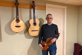 In his music room, you'll find hundreds of books related to music and woodworking, along with a keyboard, a harp, several violins and these three beautiful pieces - the first fiddle, cittern and guitar that Les Cooper handcrafted himself.