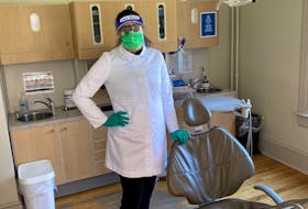 Dr. Elizabeth Jackson, a dentist at the Cornwallis Dental Centre in Kentville, N.S., shows off the new uniform for dentists. Regulations require dentists to now wear a lab jacket or gown, and either wear goggles and an N95 mask or a surgical mask with a face shield. They also now must wear scrubs and dedicated clinic shoes. They will continue to wear gloves during appointments and must always wear a mask while in the office when social distancing cannot be maintained.