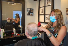 Coralee Schneider cuts Stan MacPhee's hair Friday at the Downtown Barber Shop in Charlottetown. Barbers and hairstylists on P.E.I. dealt with a steady stream of customers on their first day back in business since a mandatory shut-down in mid-March due to the pandemic.