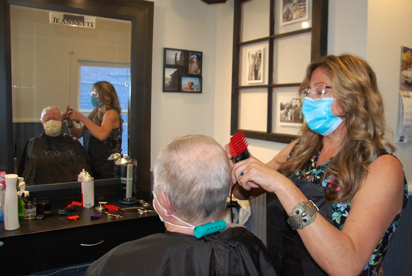 Coralee Schneider cuts Stan MacPhee's hair Friday at the Downtown Barber Shop in Charlottetown. Barbers and hairstylists on P.E.I. dealt with a steady stream of customers on their first day back in business since a mandatory shut-down in mid-March due to the pandemic.