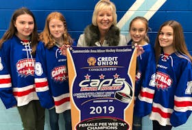 Sarah Millar, representing title sponsor Consolidated Credit Union (CCU), and four Summerside Area Minor Hockey Association players – Kayla Spencer, left; Raleigh Noonan, second left; Avery Curray, second right, and Anna Gallant – pose with the championship banner that was up for grabs during the 2019 CCU peewee A female hockey tournament at Credit Union Place recently. The Quad City Pirates from Nova Scotia edged Pownal One 2-1 in a shootout to win the championship game.
