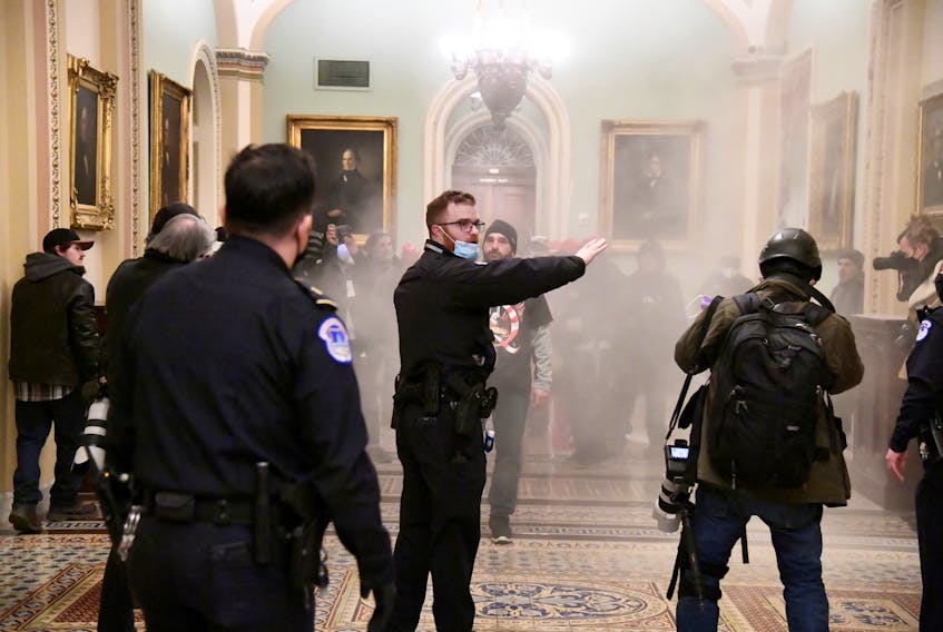 A security officer gestures after supporters of U.S. President Donald Trump breached security defenses at the U.S. Capitol, in Washington, D.C., on Wednesday. REUTERS/Mike Theiler