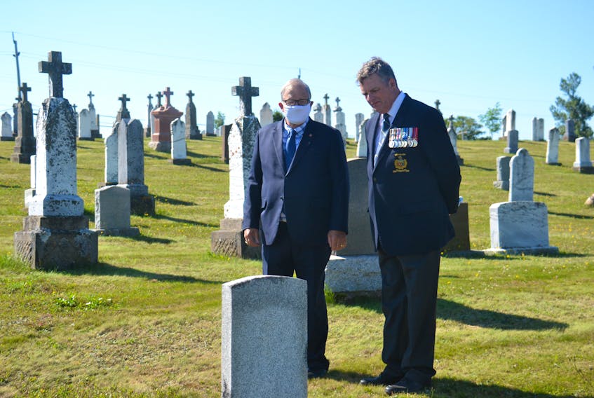 Veterans Affairs Minister Lawrence MacAulay and Owen Parkhouse, of the New Brunswick/P.E.I. branch of the Last Post Fund, observe a headstone following a funding announcement in Souris on Wednesday. Veterans Affairs Canada will contribute $100,000 to the restoration of 996 headstones of Canadian veterans across P.E.I.