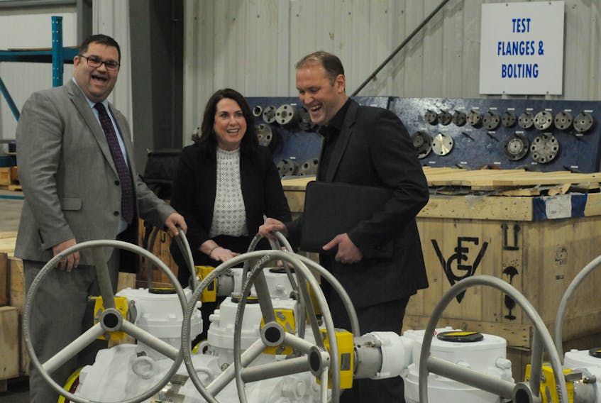 Tourism, Culture and Industry and Innovation Minister Bernard Davis (from left) Natural Resources minister Siobhan Coady and Andrew Stephen, managing director of Score Canada, stand near examples of the company’s offshore valve systems following a funding announcement in Paradise Wednesday. — Joe Gibbons/The Telegram
