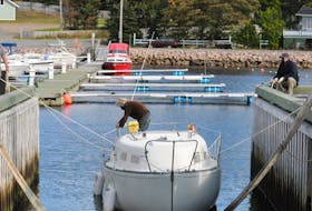 The owner of the sailboat Amanda ties ropes to his craft as it was being prepared for removal from the water at the Holyrood Marina on Wednesday afternoon to be hoisted and carried via a heavy duty lift to its spot for the upcoming winter months.
-Joe Gibbons/The Telegram 