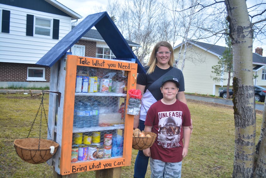 Sherri Dove and her son, Dillon, stand next to the open-air pantry she installed on her front lawn earlier this week. Nicholas Mercer/Saltwire Network 