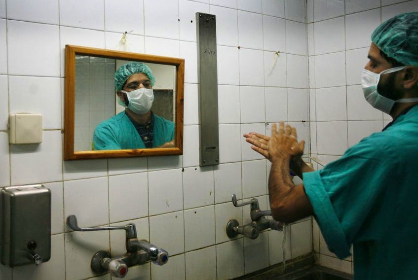 A Palestinian doctor washes his hands prior to a joint operation with U.S. doctors to help Palestinian boy Abdullah Shawwa, 4, in the Shifa hospital in Gaza City, Tuesday, Jan. 27, 2009. 