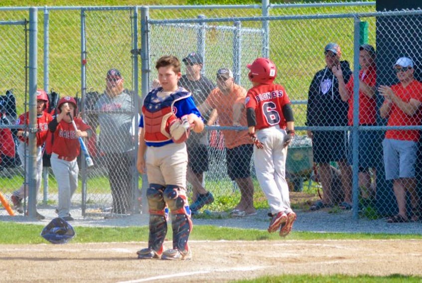 Dartmouth catcher Mitch Doucette stands at home plate while Glace Bay’s Kale MacDonald jumps for joy after scoring what would prove to be the winning run as the host All-Stars defeated the visiting Arrows in the Baseball Nova Scotia 11U AAA championships at the Cameron Bowl on Sunday afternoon.