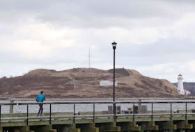 A jogger runs along the Halifax waterfront boardwalk Friday, Dec. 6, with Georges Island in the background.
