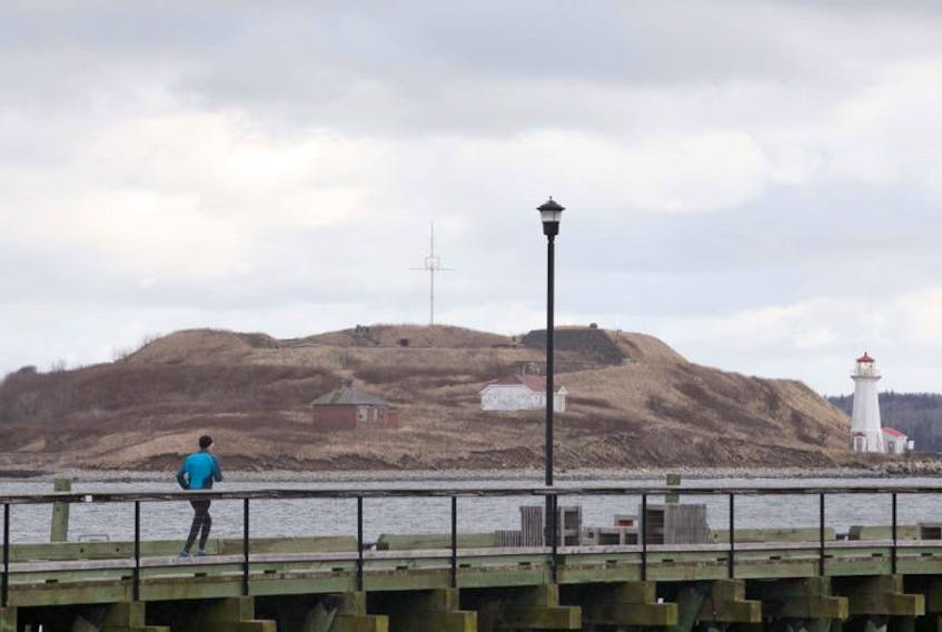 A jogger runs along the Halifax waterfront boardwalk Friday, Dec. 6, with Georges Island in the background.