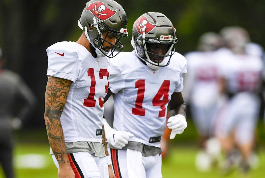Wide receivers Chris Godwin (right) and Mike Evans of the Tampa Bay Buccaneers talk things over during training camp at  the AdventHealth Training Center last month. 