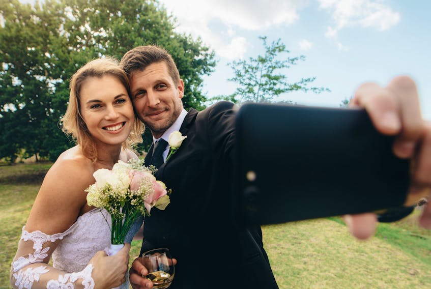 A bride and a groom are pictured taking a selfie in this file photo. (Getty Images file photo)