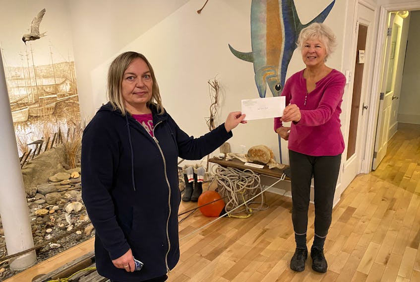Lauri Kennedy, front, from Cameron's Building Supplies, gives Elke Ibrahim, from the Glace Bay Heritage Museum, a cheque for $1,000 to help with the restoration project of Old Town Hall, where the Museum is located. The restoration project has  been ongoing for more than 20 years and Cameron's Building Supplies has been donating to the campaign since it started. CONTRIBUTED 