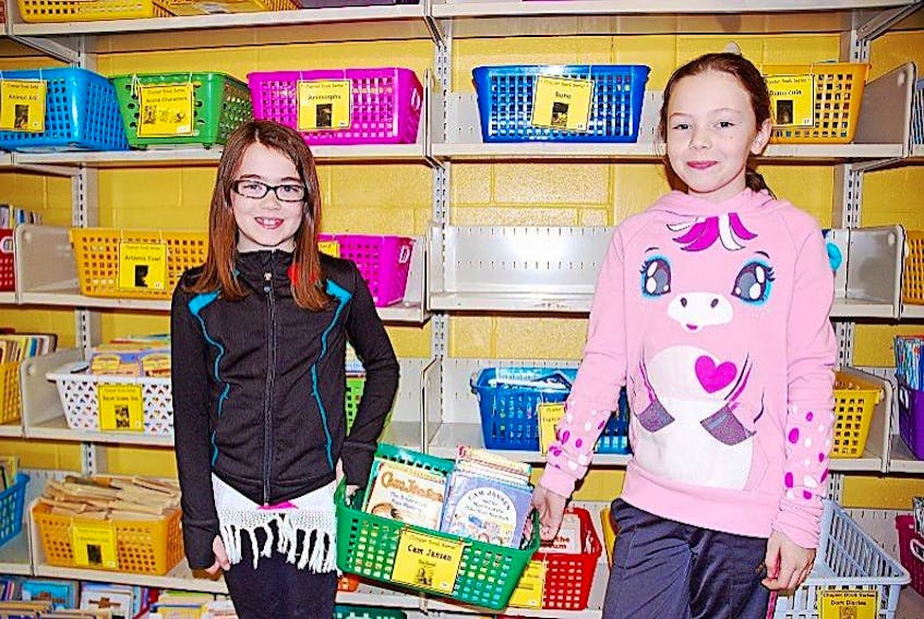Students at St. James Elementary School, including Grade 3 student Ashleigh Ingram, left, and Grade 6 student Acelyn Gillam-Young, will soon have plenty of new books to choose from after the school received $7,500 from Indigo's Adopt a School contest.