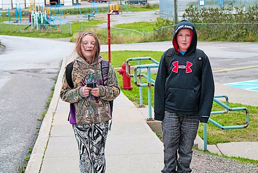 Grade 6 student Lily Warren and Grade 5 student Donovan Thompson walk to school. 
