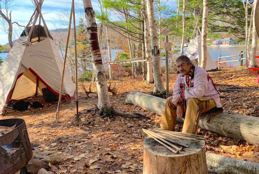 Lindsay Paul takes a break while tending the fire at his mock village along the Eskasoni Cultural Journeys Goat Island trail.