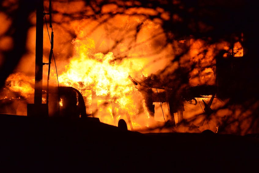 Firefighters battle a blaze at Woodland Farm on Back Line in Goulds Feb. 22. A barn was destroyed and reportedly 70 cows died in the fire.