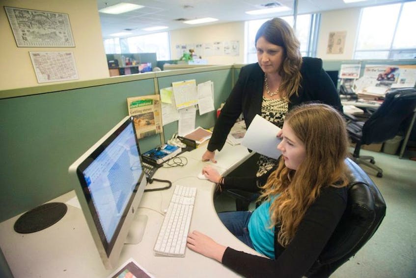 <p>Grace Lloyd, a Grade 9 student at Queen Charlotte Intermediate School, works on a story at The Guardian’s news room while her mother, news editor Jocelyne Lloyd, looks over her work.</p>