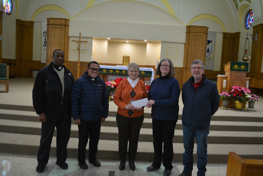 The Immaculate Conception Cathedral Parish in Grand Falls-Windsor is helping with the restoration of St. Matthew's Presbyterian Church razed by fire last fall. On Jan. 21, the Roman Catholic church donated $2,200 it raised through its annual Advent envelope collection. Left to right are: Father Gabriel Awuafor, parish administrator Father Joseph Uy, finance committee chairperson Pauline Power, St. Matthew's treasurer Lynne Allan and St. Matthew's board chairman Bob Thompson. Contributed photo