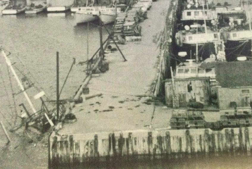 <p>A sunken vessel’s mast protrudes above the water near the Clark’s Harbour wharf.&nbsp;</p>