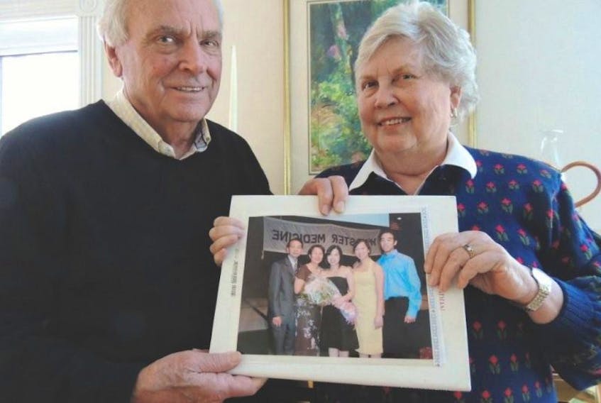 <p>Derek and Jennifer Grout are pictured with a photo of the Kim family, who fled political and economic turmoil in their native Vietnam and were resettled as refugees in New Glasgow in 1979. The Kims and extended family later moved to Toronto but maintain ties with friends in Pictou County. (Rosalie MacEachern photo)</p>