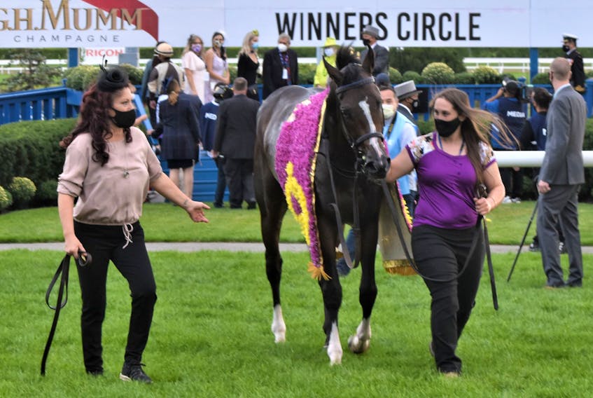 Siobhan Brown of Groves Point, right, is shown with Mighty Heart, the Queen’s Plate winner, and Renee Dockstader, left, in the winner’s circle at Woodbine Racetrack in Etobicoke, Ont., Saturday. Brown is the groom for the three-year-old colt, who like herself has overcome challenges in life to be successful. CONTRIBUTED/WILL WONG