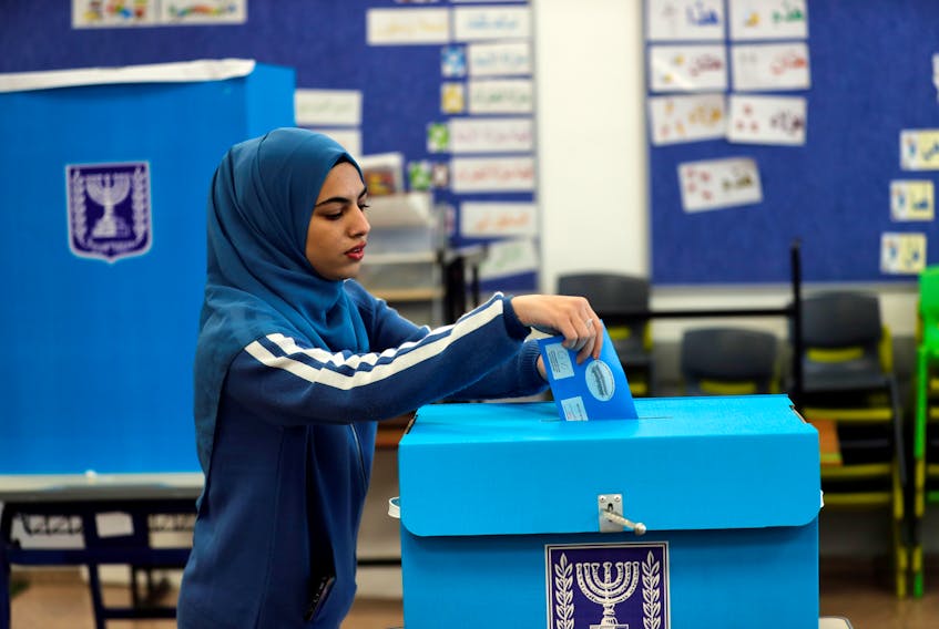 An Arab-Israeli woman casts her ballot as she votes in Israel’s national election at a polling station in  Tamra, Israel, March 2 - REUTERS/Ammar Awad