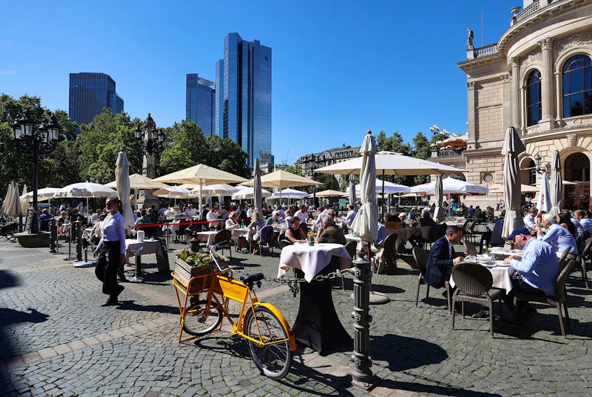 People enjoy the sun while having lunch next to the old opera house in the financial district of Frankfurt, Germany, Sept. 8, 2020, REUTERS/Kai Pfaffenbach
