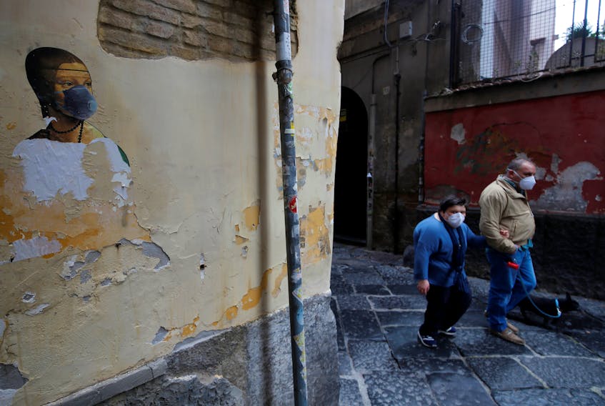 An image of Leonardo da Vinci’s “Lady with an Ermine” wearing a face mask is seen in Naples, Italy, Friday. — Reuters