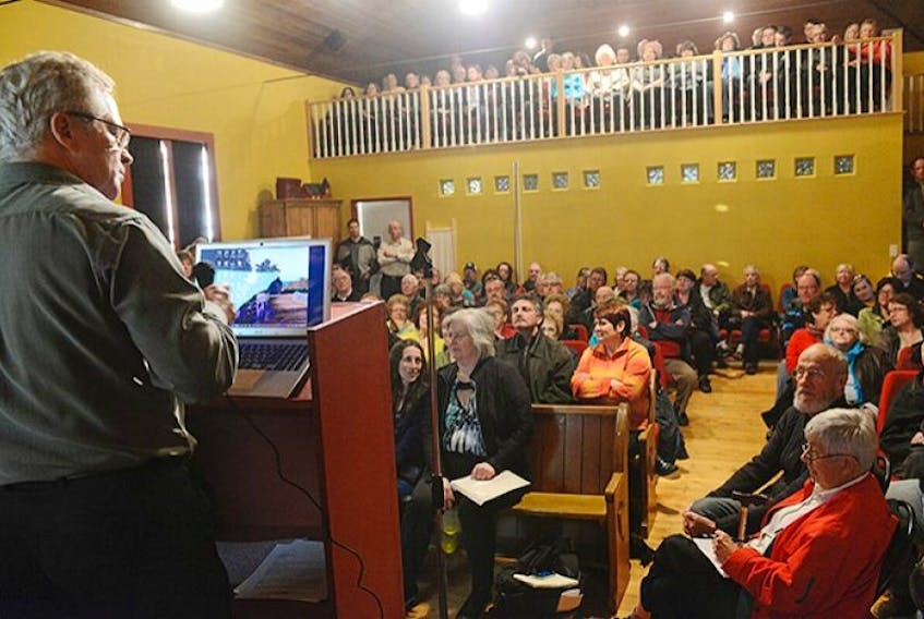 Sandy Foy, left, prepares to speak to a standing-room-only crowd at Bites Café in Hampton. Residents of the area suspect that some large-scale development is planned for the unincorporated area, but can't find out what it is. Foy spoke of his successful appeal against existing development activity in the same area.