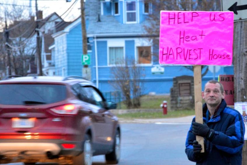 Colin Sanford holds a sign in support of Harvest House on a cold night in Windsor.