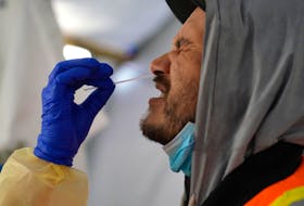 A provincial health worker performs a COVID-19 nasal swab test on Raymond Robins of the remote First Nation community of Gull Bay, Ont., on April 27, 2020.