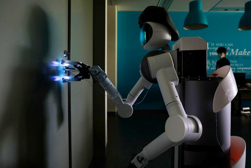 Mira Robotics' Ugo avatar robot sterilizes a door handle with ultraviolet light during a demonstration at the company's laboratory in Kawasaki, Japan, on June 8, 2020. 