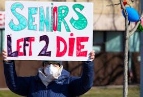  A person holds a sign outside Residence Herron, a seniors’ long-term care facility, following a number of deaths there during the COVID-19 outbreak, in the Montreal suburb of Dorval, April 11, 2020.