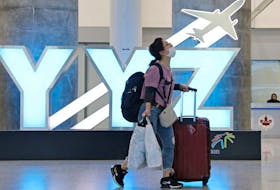 A traveller passes a YYZ airport code sign in the international arrival lounge amid a growing global number of coronavirus cases at Pearson Airport in Toronto, March 13, 2020.  