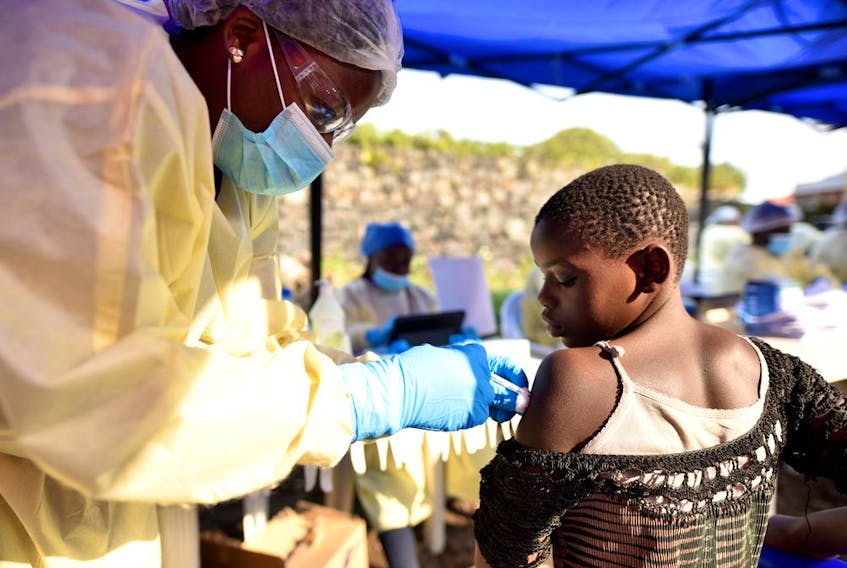 A young woman reacts as a health worker injects her with the Ebola vaccine, in Goma, Democratic Republic of Congo, August 5, 2019. 