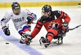 In this May 3, 2019 file photo, Liam Hickey of Canada moves the puck ahead of a South Korean defender during a semifinal game at the world para hockey championship in Ostrava, Czech Republic. Hickey is not at the national para hockey training camp in Calgary, but nobody — including Hickey — thinks that will jeopardize his chance at playing at the next world championship or Paralympics. — File/Paralympic.ca
