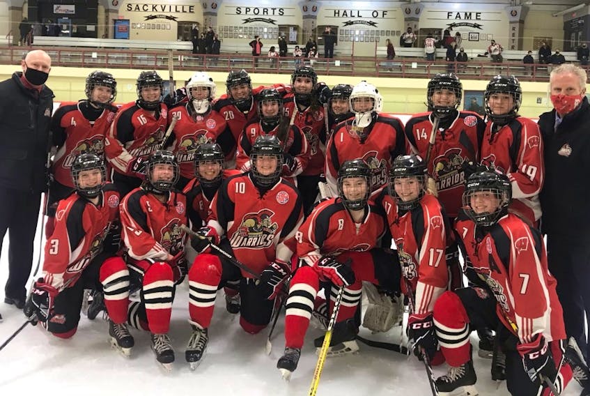 Members of the Halifax West Warriors girls' hockey team celebrate after winning the metro high school league regional championship.