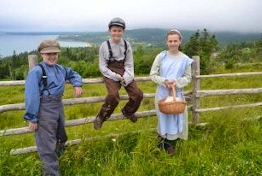 ["From left, Stephen Chaisson, Aidan MacNeil and Zoie Chaisson take a break before heading off the Highland Village's log cabin to learn about spinning wool as part of Happy Days/Laithean Sona, a children's living history program."]