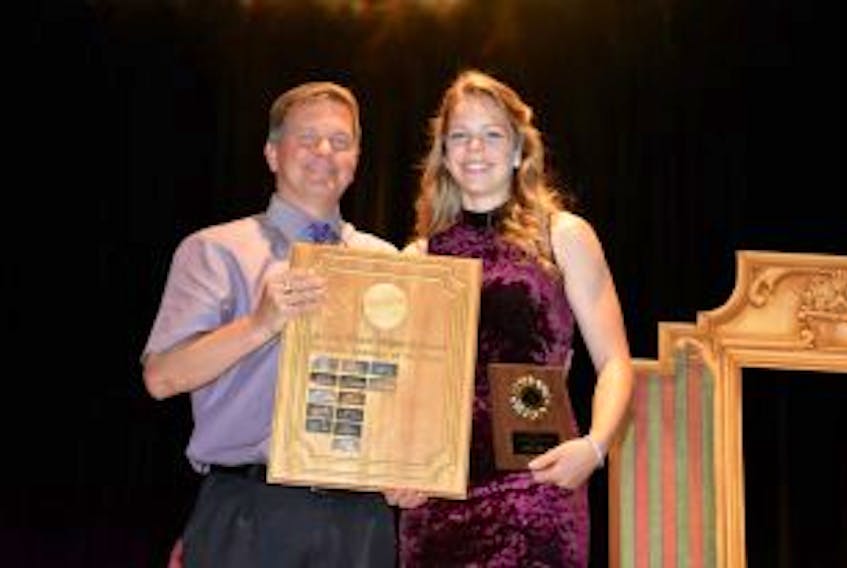 ["Jessie Bryan accepts the Female Athlete of the Year Award from Jim Bryan, the athletics director, during Avon View High School's 2016-17 sports banquet."]