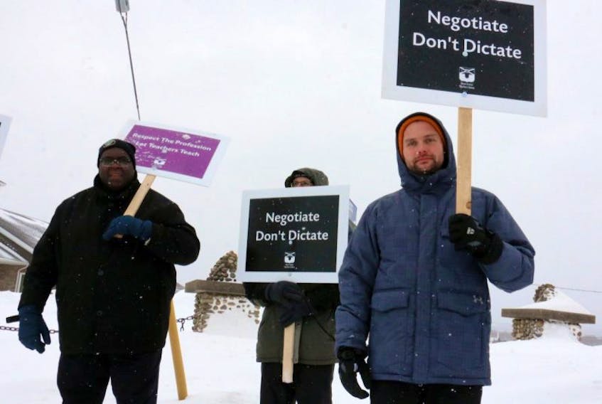 Avon View teachers James Streeter, Dave Margolian, and Shane Goucher waved picket signs while participating in the first-ever teachers strike in the province.