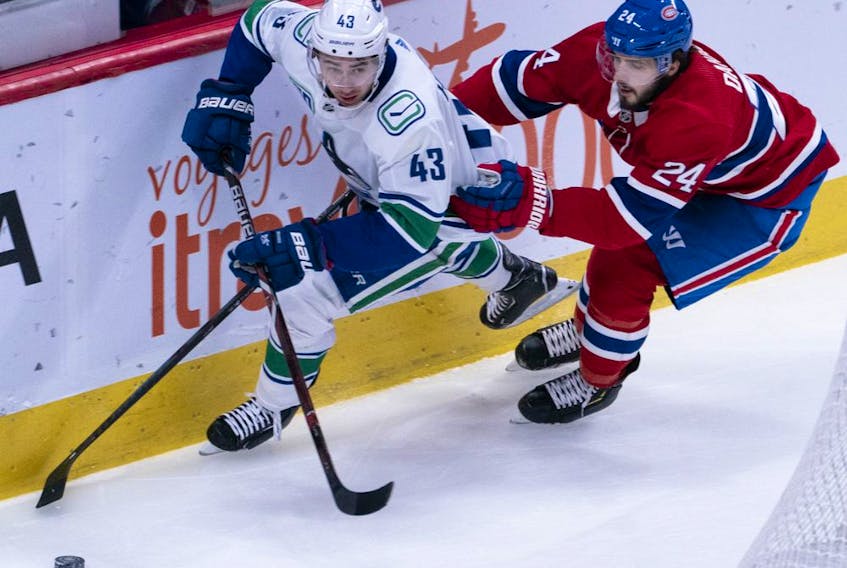 Defenceman Quinn Hughes of the Vancouver Canucks is chased by Montreal Canadiens' Phillip Danault during NHL action in Montreal on Feb. 25.