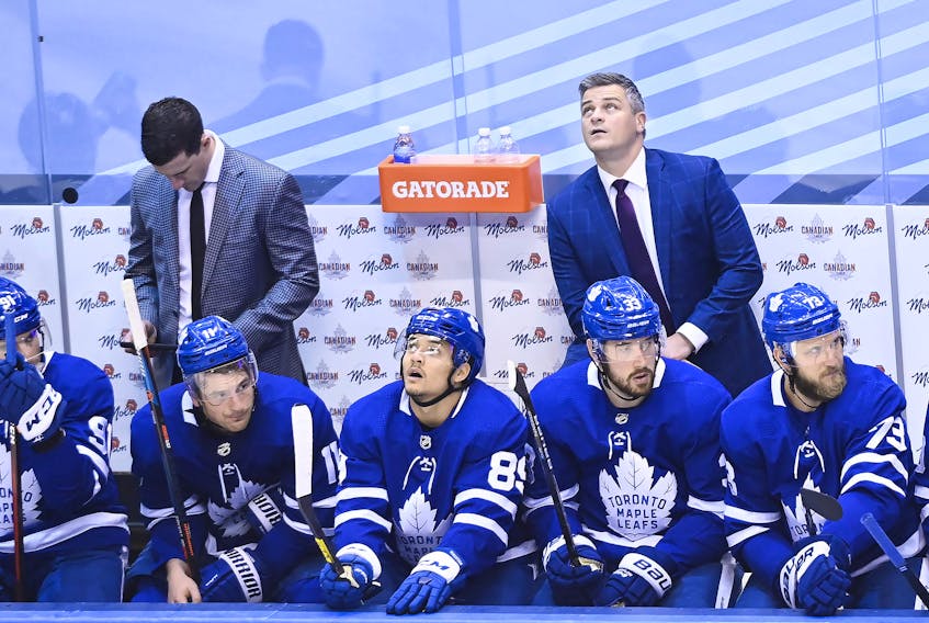 Toronto Maple Leafs head coach Sheldon Keefe, back right, looks at the score board in the final seconds of third period NHL Eastern Conference Stanley Cup playoff action against the Columbus Blue Jackets, in Toronto, Sunday, Aug. 2, 2020. 