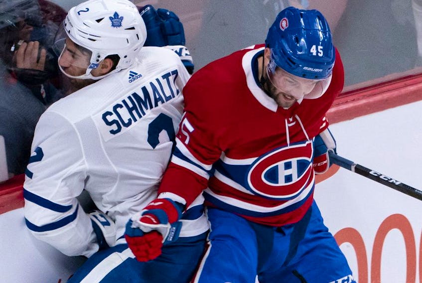 Jordan Schmaltz of the Toronto Maple leafs is rammed into the boards by Riley Barber of the Montreal Canadiens during pre-season action in Montreal on Monday, Sept. 23, 2019.