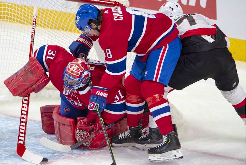 Canadiens goaltender Carey Price grabs a loose puck as Montreal defenceman Ben Chiarot and Senators' Brady Tkachuk battle for the rebound during the first period Tuesday night at the Bell Centre.