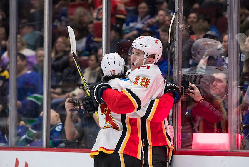 CP-Web.  Calgary Flames' Matthew Tkachuk (19) and Johnny Gaudreau (13) celebrate Tkachuk's goal against the Vancouver Canucks during the first period of an NHL hockey game in Vancouver, on Saturday February 8, 2020. THE CANADIAN PRESS/Darryl Dyck ORG XMIT: VCRD104