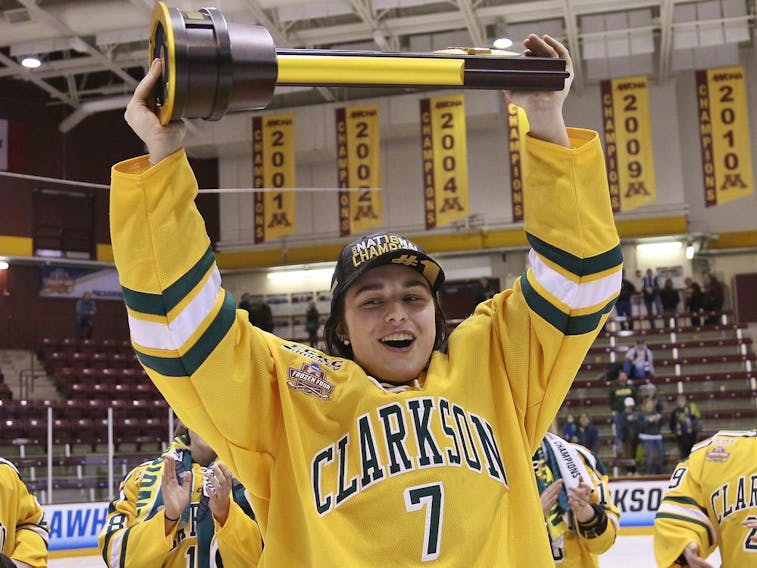 larkson's Elizabeth Giguère holds up the team's trophy after Clarkson defeated Colgate 2-1 in overtime in the NCAA college women's hockey Frozen Four championship game in Minneapolis on March 18, 2018. 