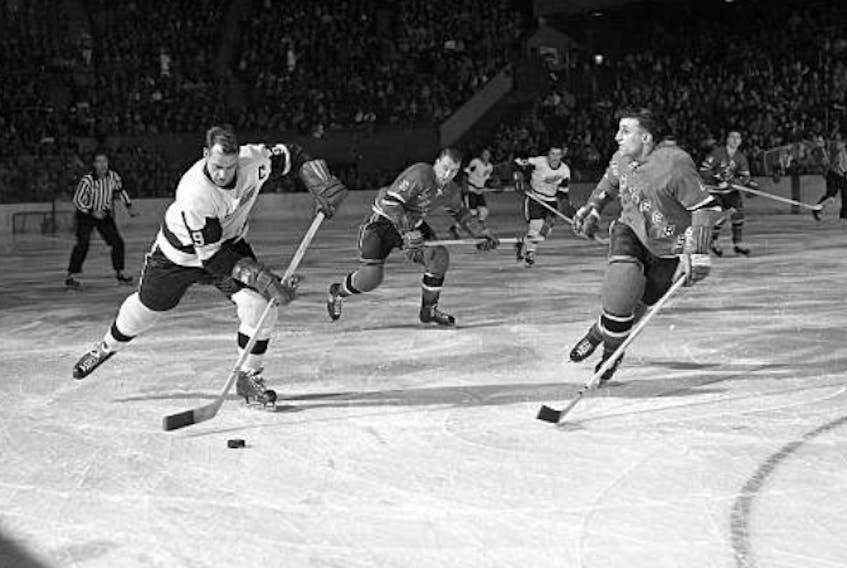 The Legendary Gordie Howe, left, streaks down the ice as Sydney's John (Junior) Hanna, of the New York Rangers, prepares to angle him toward the boards. This photo appeared in the New York Times around 1959. Its caption indicated that Hanna was successful in denying Mr. Hockey a scoring opportunity on that particular play at Madison Square Garden in New York. CONTRIBUTED 