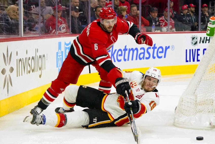 Carolina Hurricanes defenceman Joel Edmundson knocks Calgary Flames left-wing Matthew Tkachuk to the ice during the third period at PNC Arena on Oct. 29, 2019. 