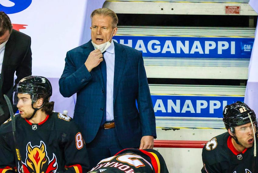 Feb 17, 2021; Calgary, Alberta, CAN; Calgary Flames head coach Geoff Ward (top, right) reacts from the bench during the first period against the Vancouver Canucks at Scotiabank Saddledome. Mandatory Credit: Sergei Belski-USA TODAY Sports